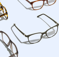 Variety of stylish eyeglass frames, including tortoiseshell and matte green Luxreaders, on a light grey background.
