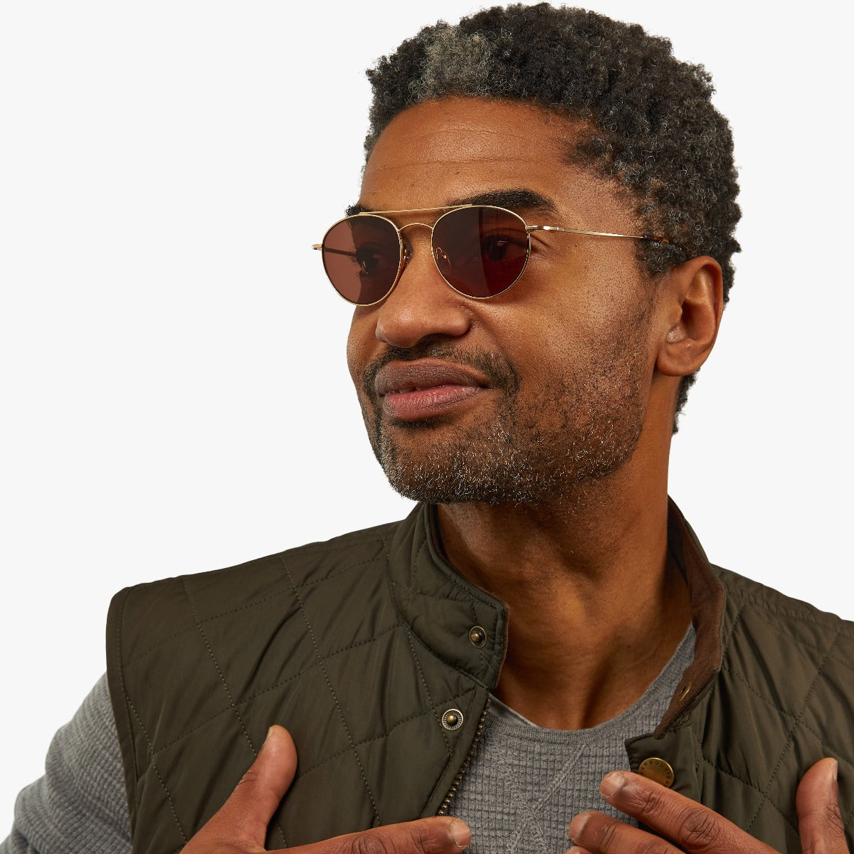 Person wearing Göteborg Gold glasses with gold frames and brown lenses