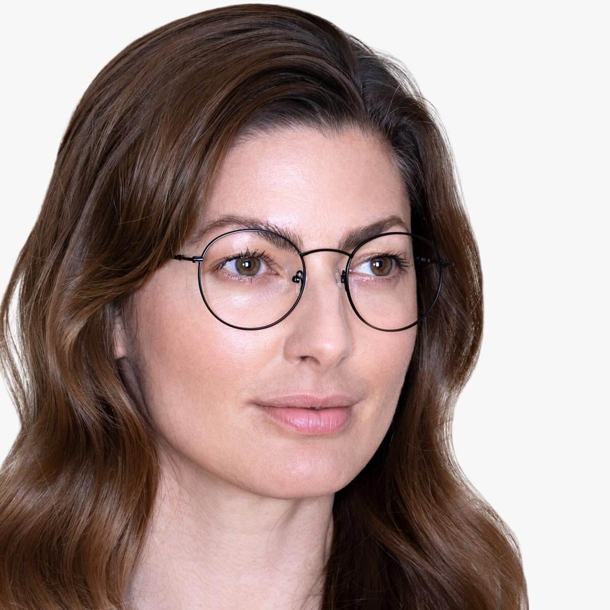 Person wearing Tromsø Black round glasses with thin metal frame