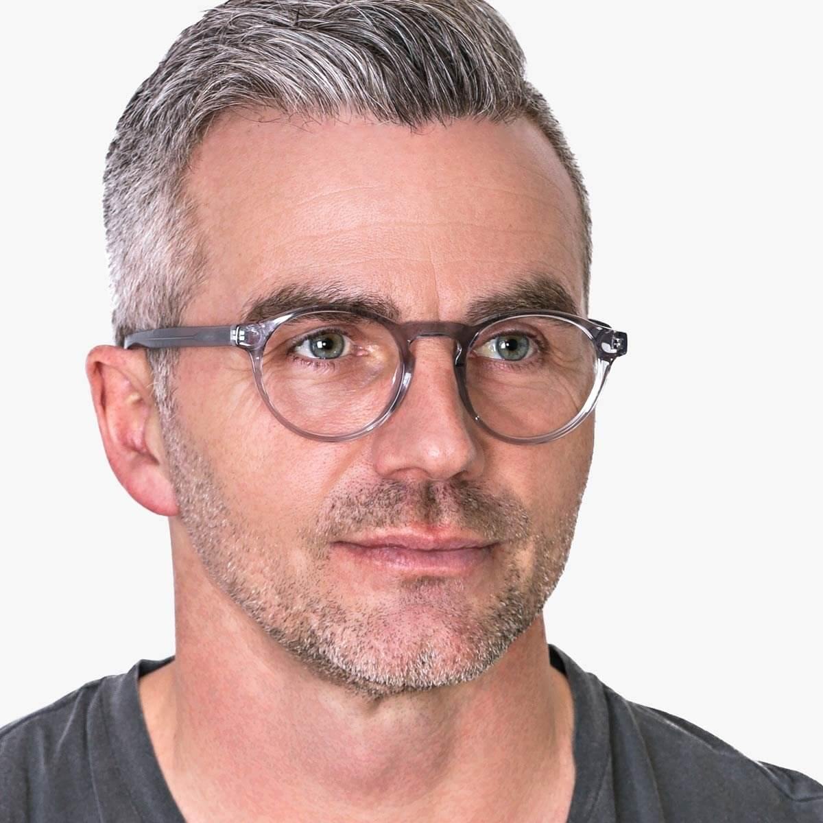 Person wearing Trondheim Crystal Grey reading glasses